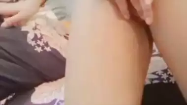 The naked girl fingers her wet pussy during a video call sex